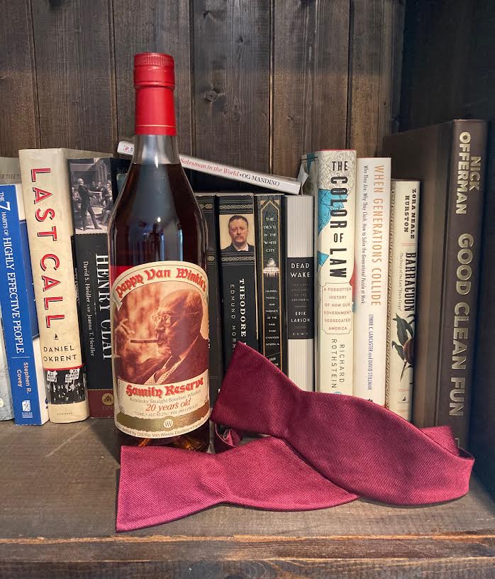 Pappy Van Winkle 20 year bourbon, books, bow tie on a hand made wooden bookcase 